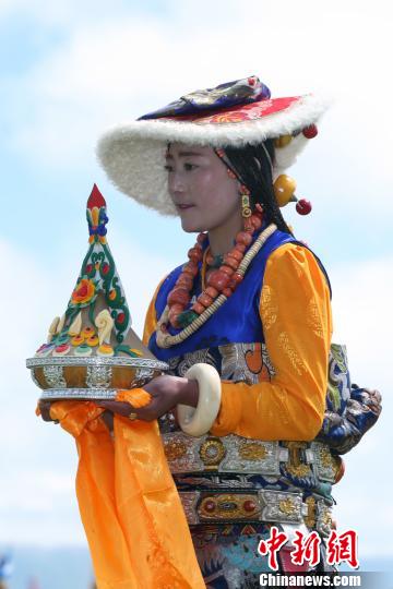 图为入场仪式上手捧切玛的康巴姑娘。 罗云鹏 摄 图为入场仪式上手捧切玛的康巴姑娘。 罗云鹏 摄