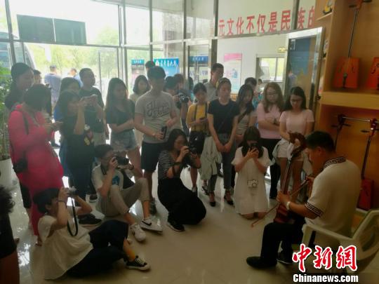 图为旺盛现场为香港学子弹奏马头琴。 张林虎 摄 图为旺盛现场为香港学子弹奏马头琴。 张林虎 摄